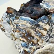 Load image into Gallery viewer, Close-up of the intricate black and blue bubbly textures on this unique agatized coral geode
